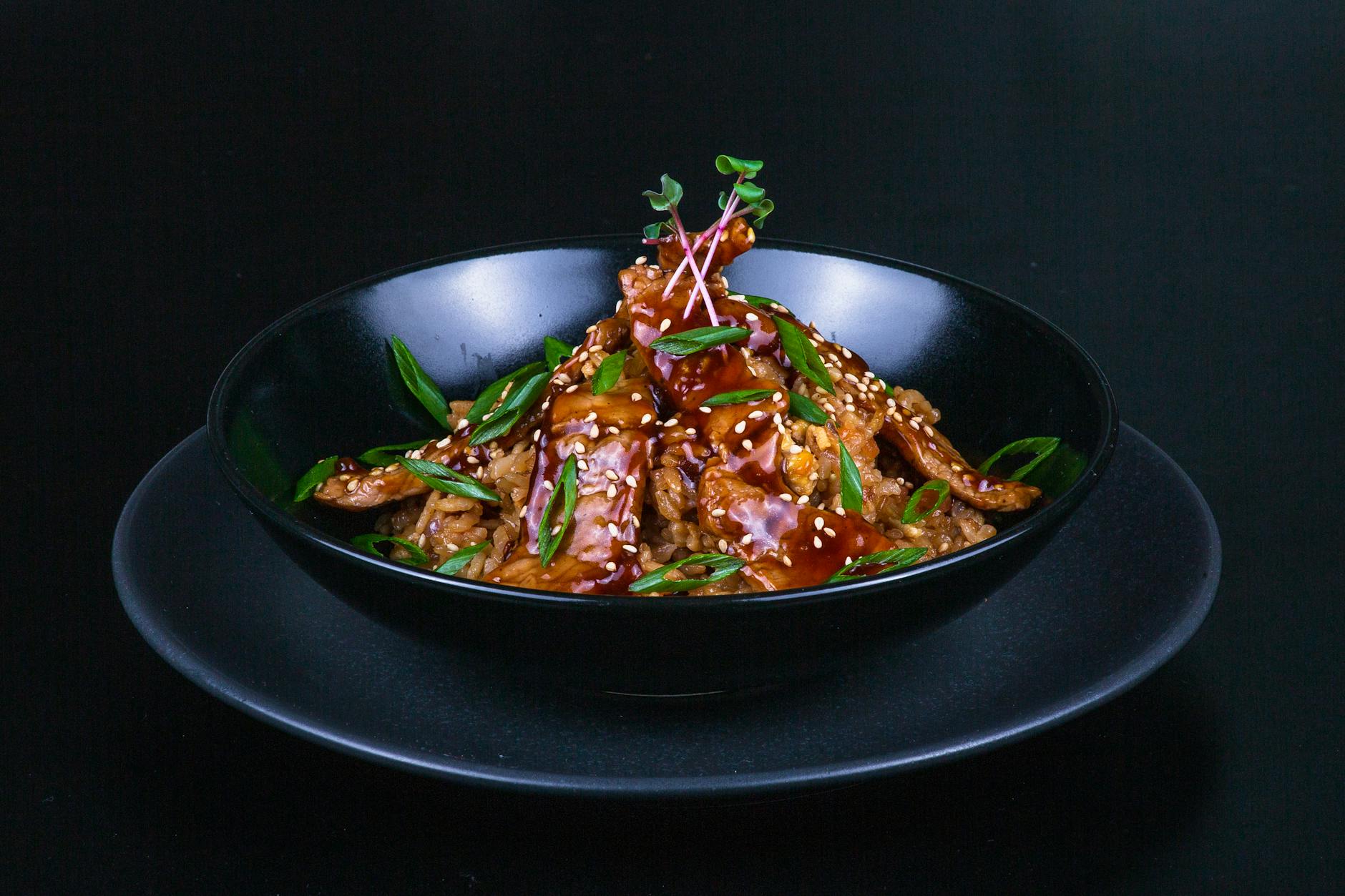 Glossy teriyaki chicken over white rice with sesame seeds