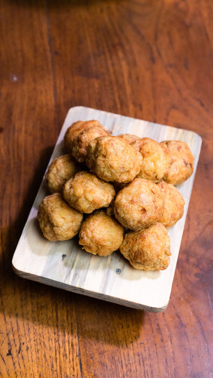 Golden homemade meatballs stacked on a rustic wooden board