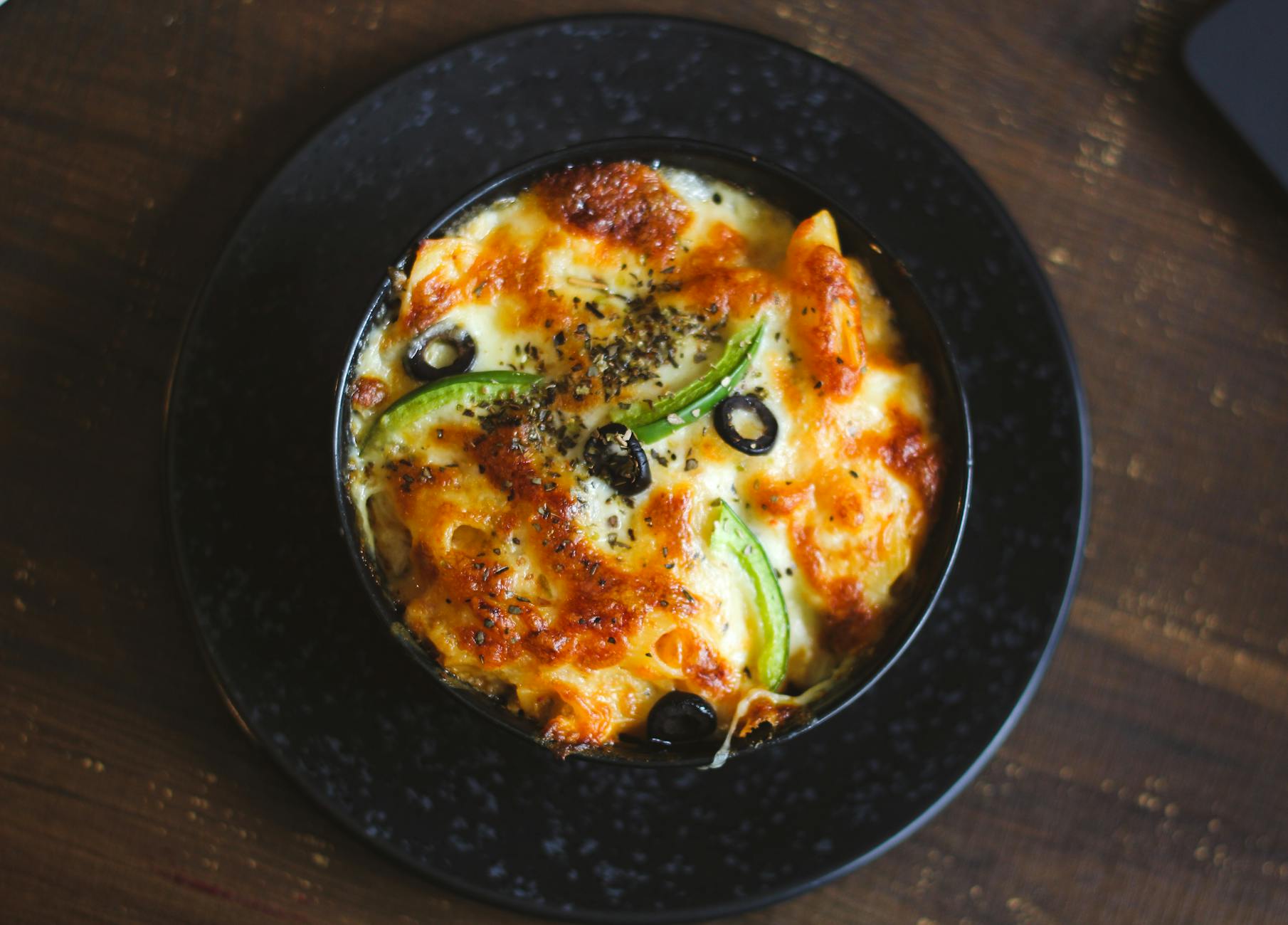 Baked ziti with bubbly cheese crust in a casserole dish