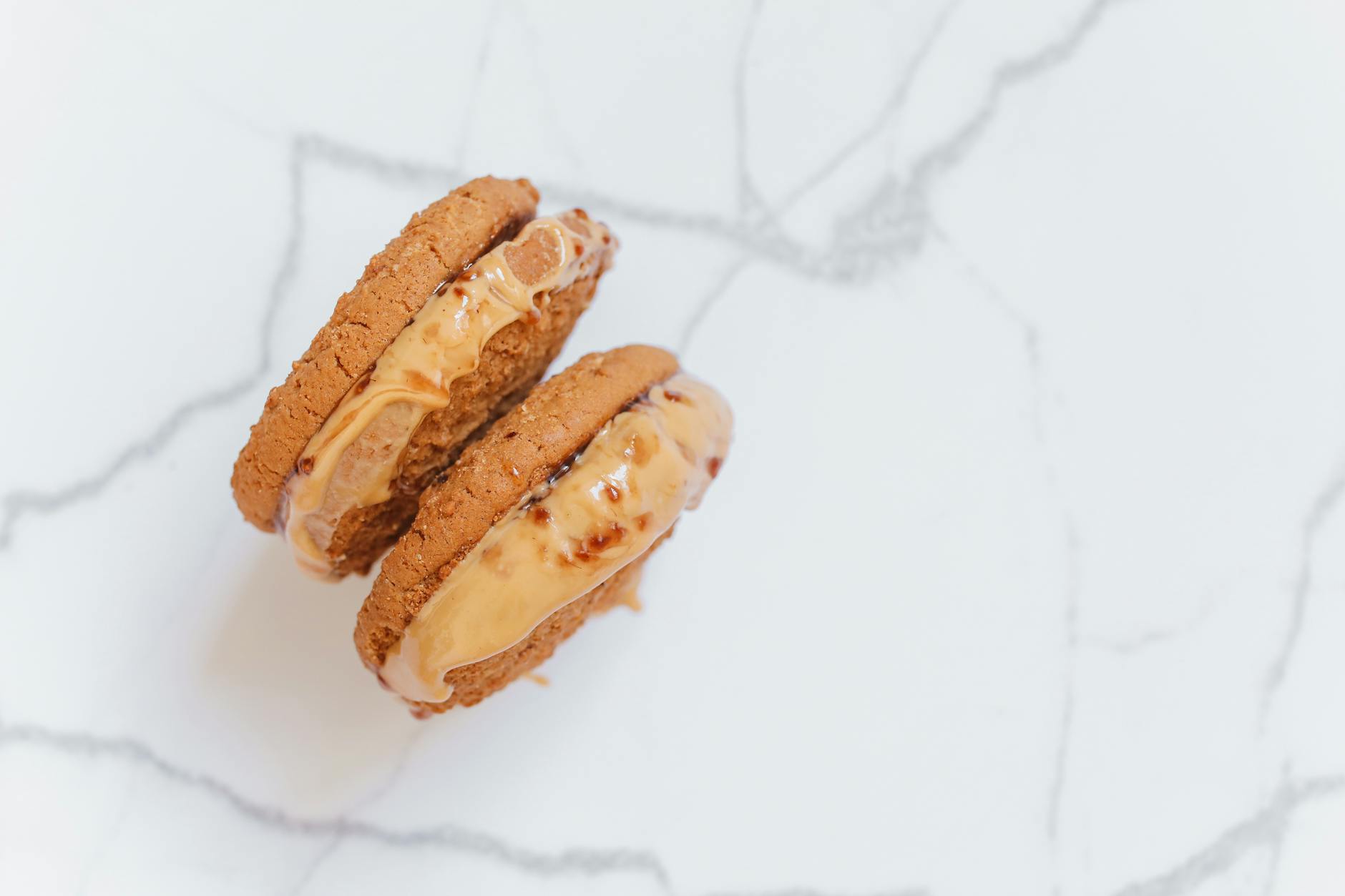 Peanut butter cookies with fork crosshatch marks on a baking sheet