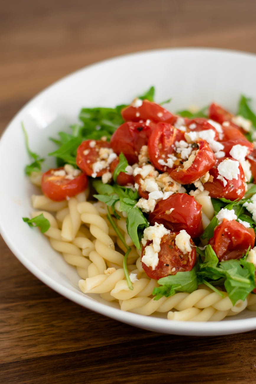 Pasta with cherry tomatoes and feta cheese in a ceramic bowl