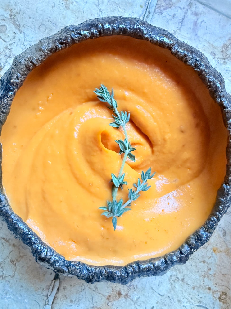 A bowl of vibrant orange roasted carrot soup