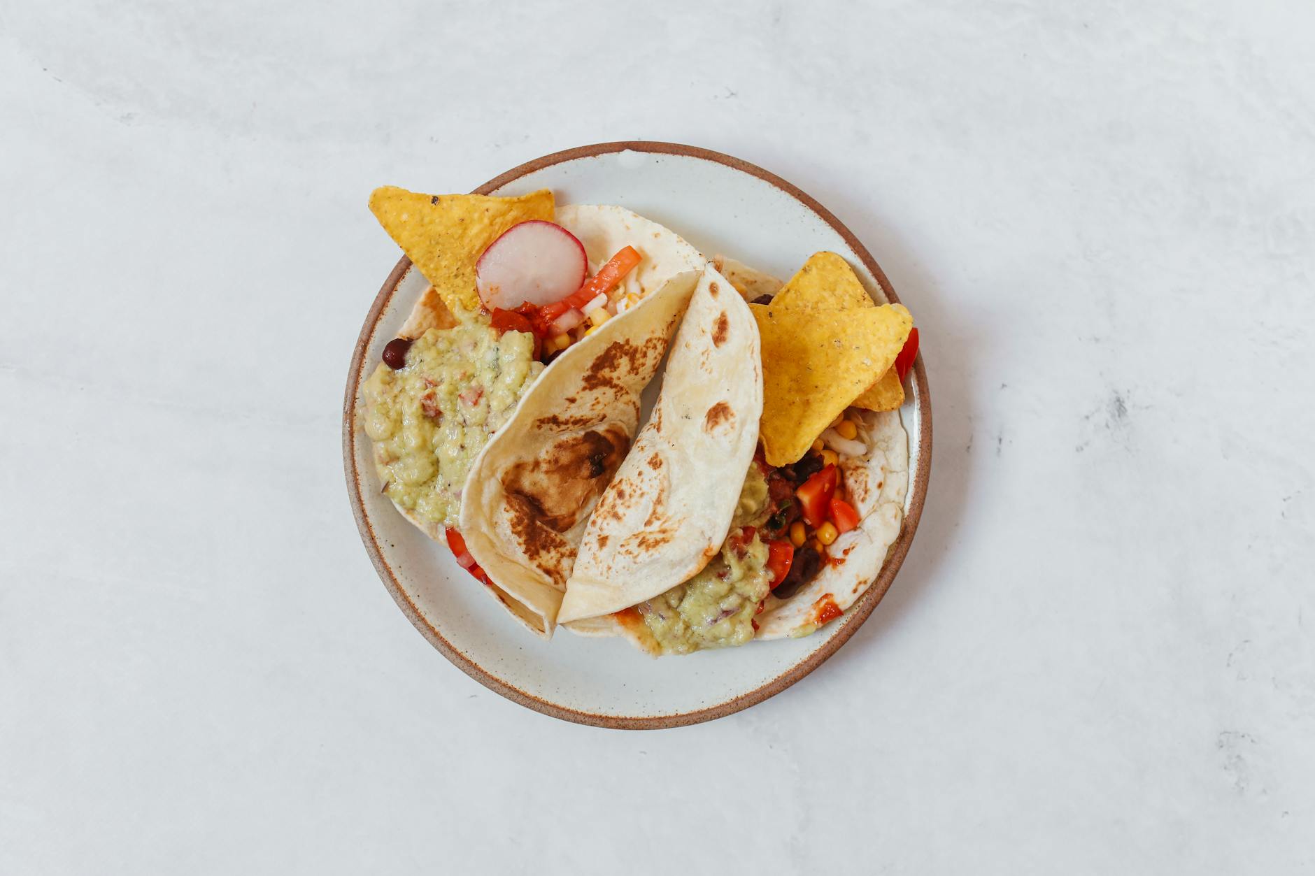 Black bean tacos on corn tortillas with lime wedges