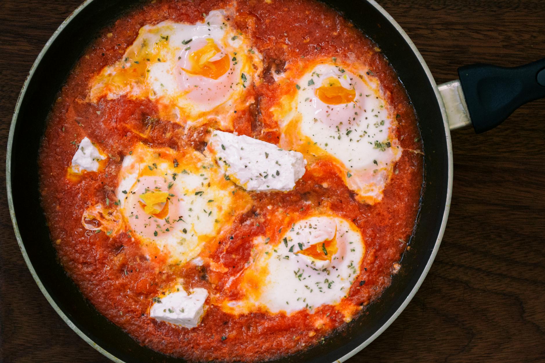 Eggs poached in spiced tomato sauce in a cast iron skillet