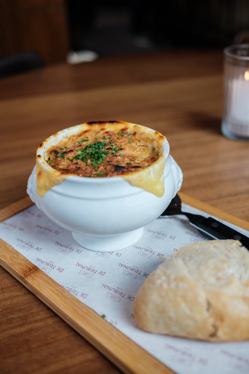 French onion soup with melted cheese on top in a crock