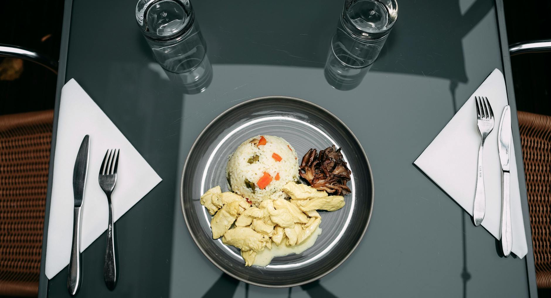 Golden skin-on chicken thighs on seasoned rice in a skillet