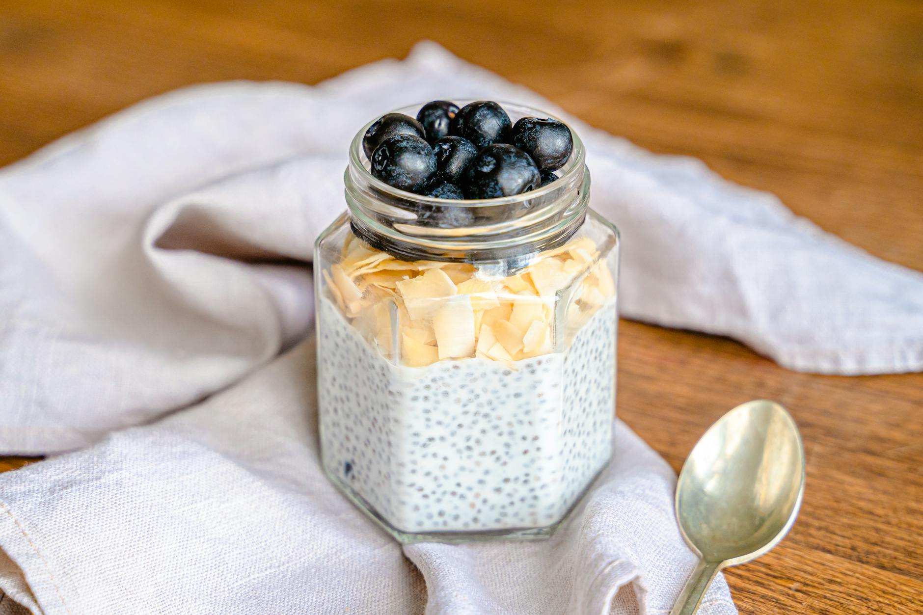 Chia pudding jar topped with fresh berries and granola